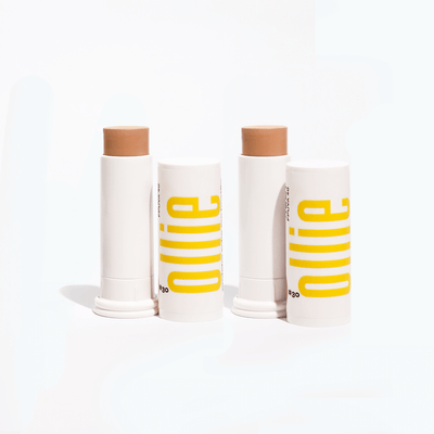 Ollie Kit TBD with two tinted sunscreen sticks SPF 95 in medium shades, ideal for natural coverage and daily sun protection